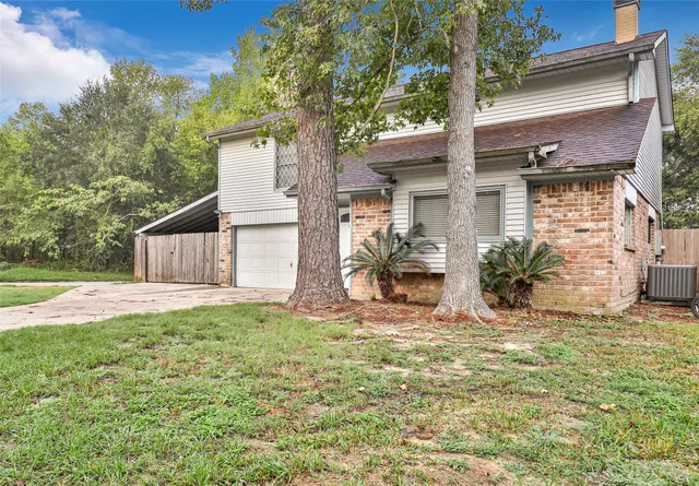 a view of a house with backyard and a tree