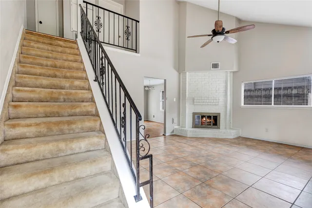 a view of staircase with white walls and fireplace