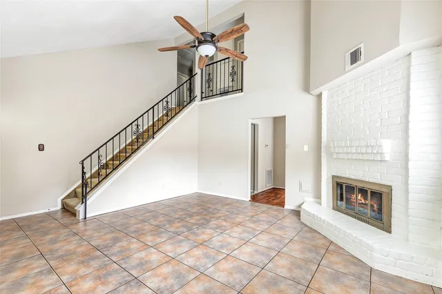 a view of staircase with a fireplace and a rug