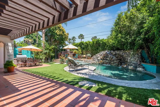 a view of a patio with table and chairs under an umbrella