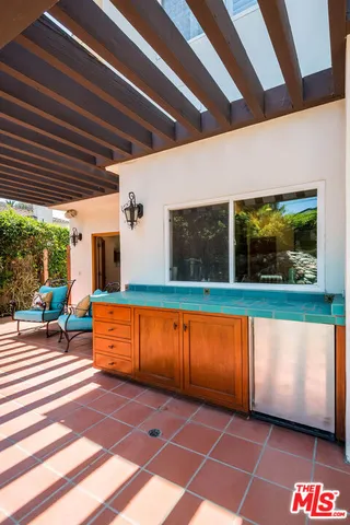 a living room with furniture kitchen view and a large window