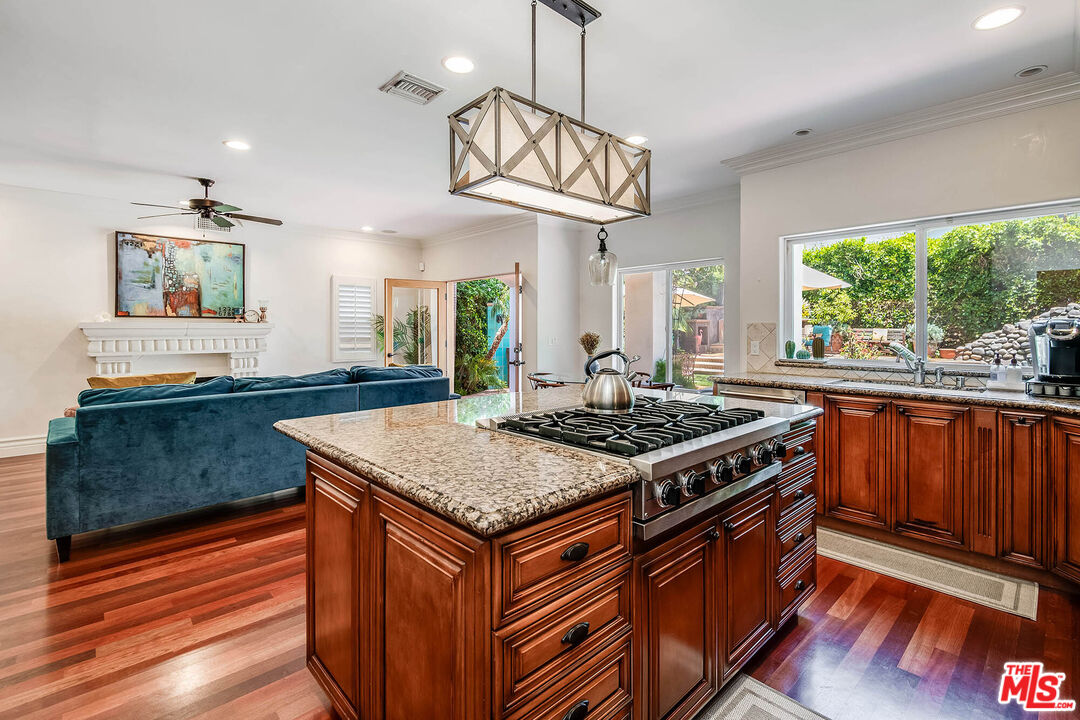 4520 Tyrone Avenue Sherman Oaks, CA 91423 - Photo 29 of 61 a kitchen with stainless steel appliances granite countertop a stove a sink dishwasher and a dining table with wooden floor