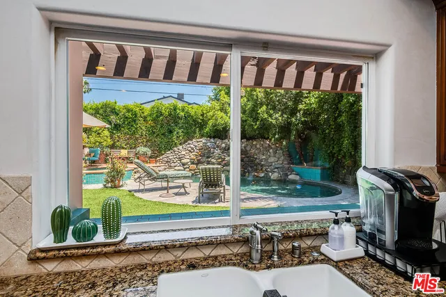 a bathroom with a granite countertop sink a toilet a mirror and shower