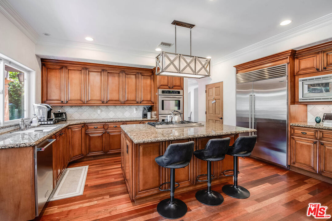 4520 Tyrone Avenue Sherman Oaks, CA 91423 - Photo 31 of 61 a kitchen with stainless steel appliances granite countertop a sink a stove and a wooden floors