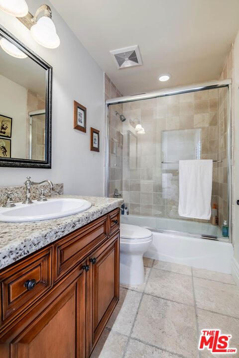 4520 Tyrone Avenue Sherman Oaks, CA 91423 - Photo 38 of 61 a bathroom with a granite countertop sink a toilet a mirror and shower