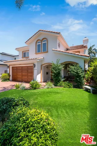 a front view of a house with a yard and potted plants