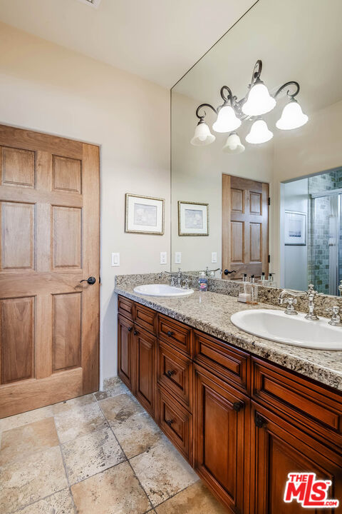 4520 Tyrone Avenue Sherman Oaks, CA 91423 - Photo 51 of 61 a bathroom with a granite countertop sink and a mirror