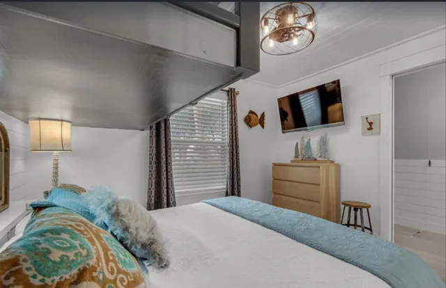 a bedroom with a bed and a flat screen tv