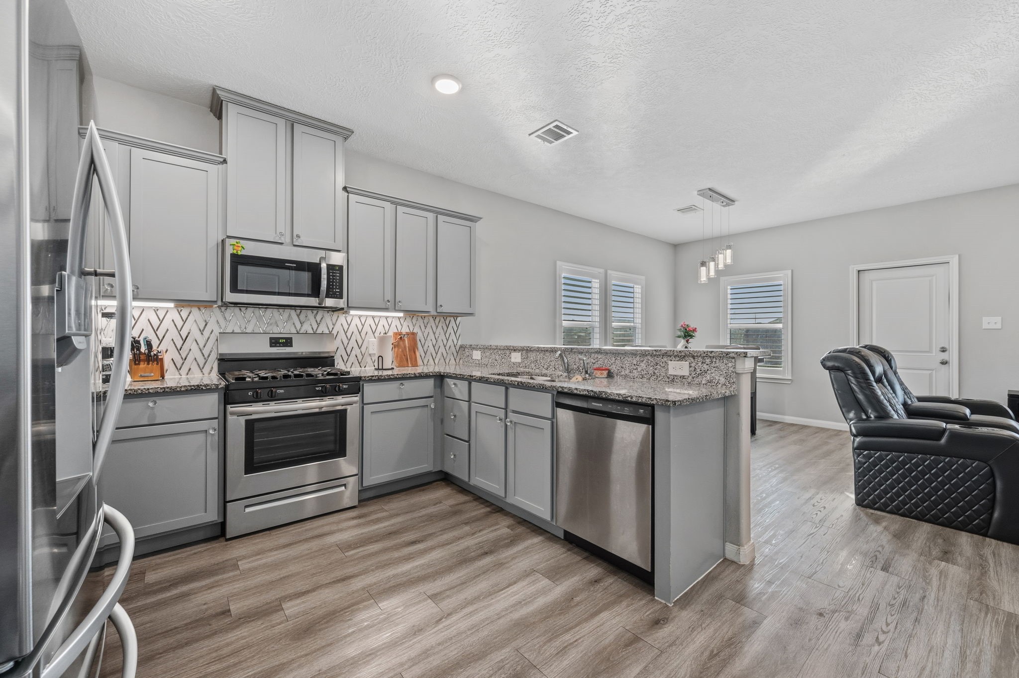 727 Road 5105 Cleveland, TX 77327 - Photo 4 of 22 a kitchen with granite countertop a stove top oven a sink dishwasher a refrigerator and cabinets with wooden floor