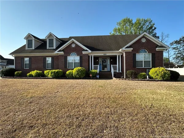 a front view of a house with a yard and potted plants