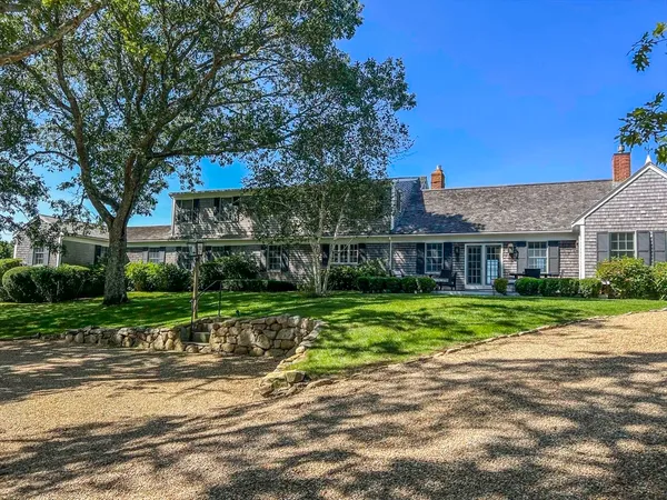 a view of a big house with a big yard and large trees