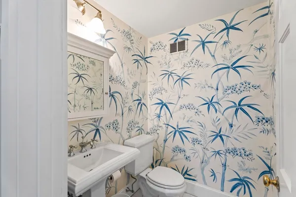 a bathroom with a toilet sink and mirror