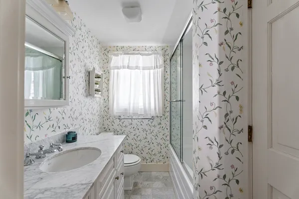 a bathroom with a granite countertop sink a toilet and shower curtain