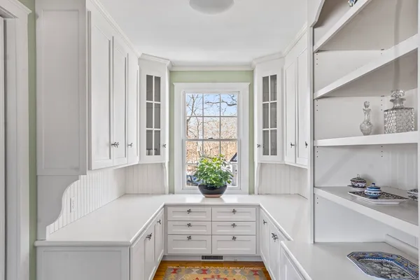 a kitchen with a white cabinets and window