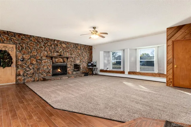 wooden floor fireplace and windows in an empty room