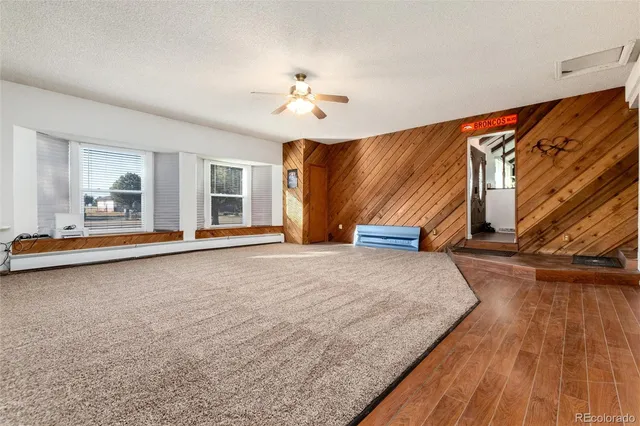 a spacious bedroom with a bed and wooden floor