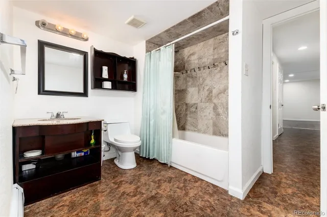 a bathroom with a toilet a sink and mirror