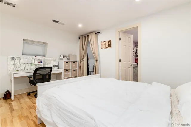 a bed room with a bed and a view of kitchen