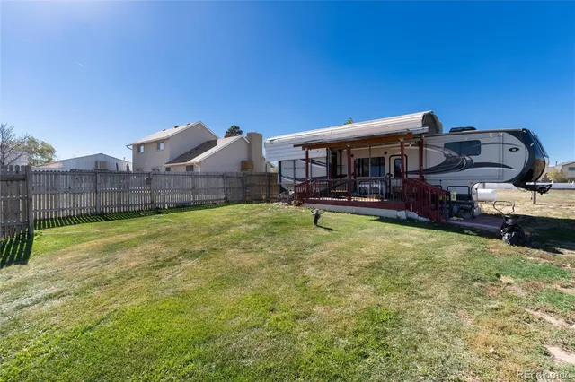 a view of a big house with a big yard and large trees