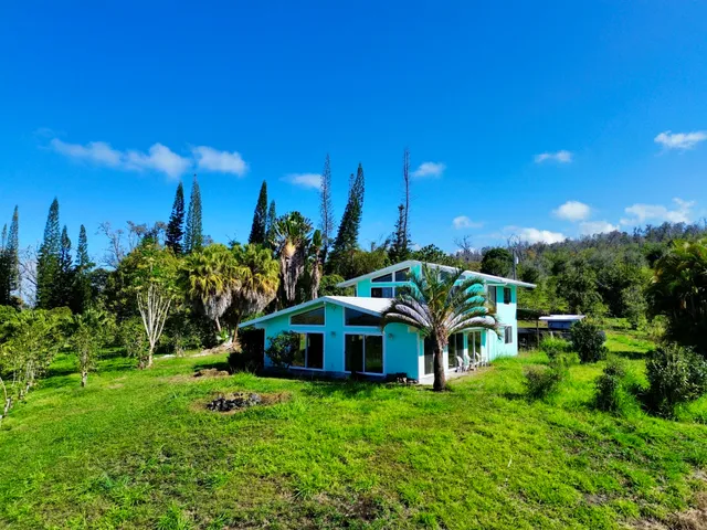 a yellow house with trees in front of it