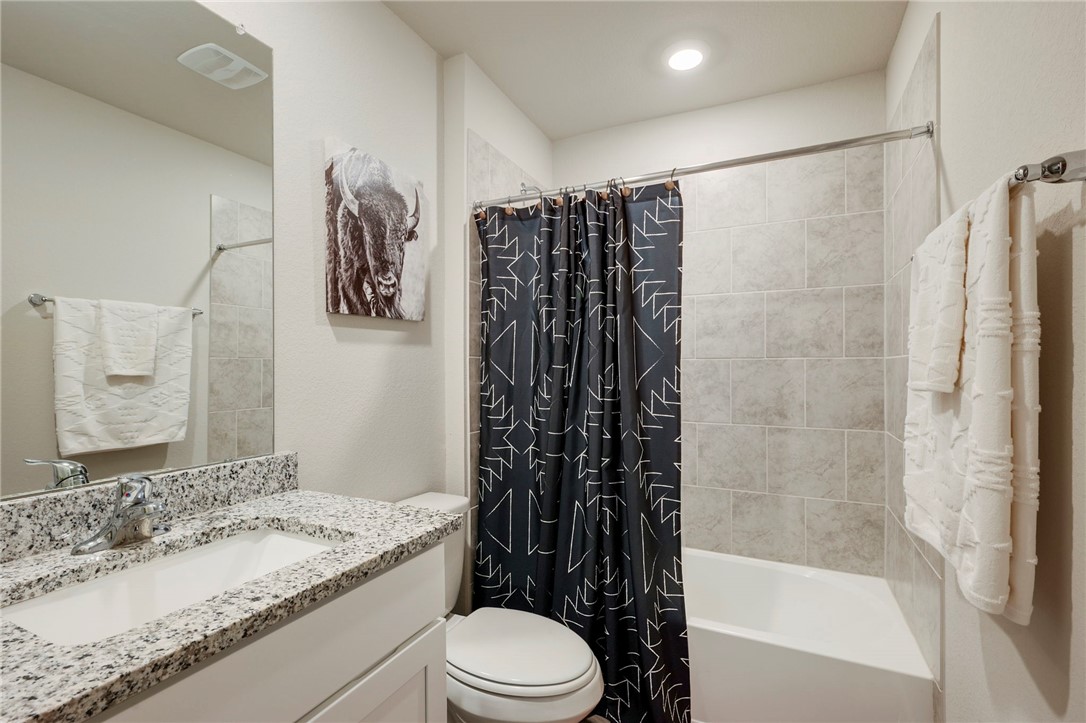 8026 Front Nine Lane Navasota, TX 77868 - Photo 14 of 22 a bathroom with a granite countertop sink toilet and shower