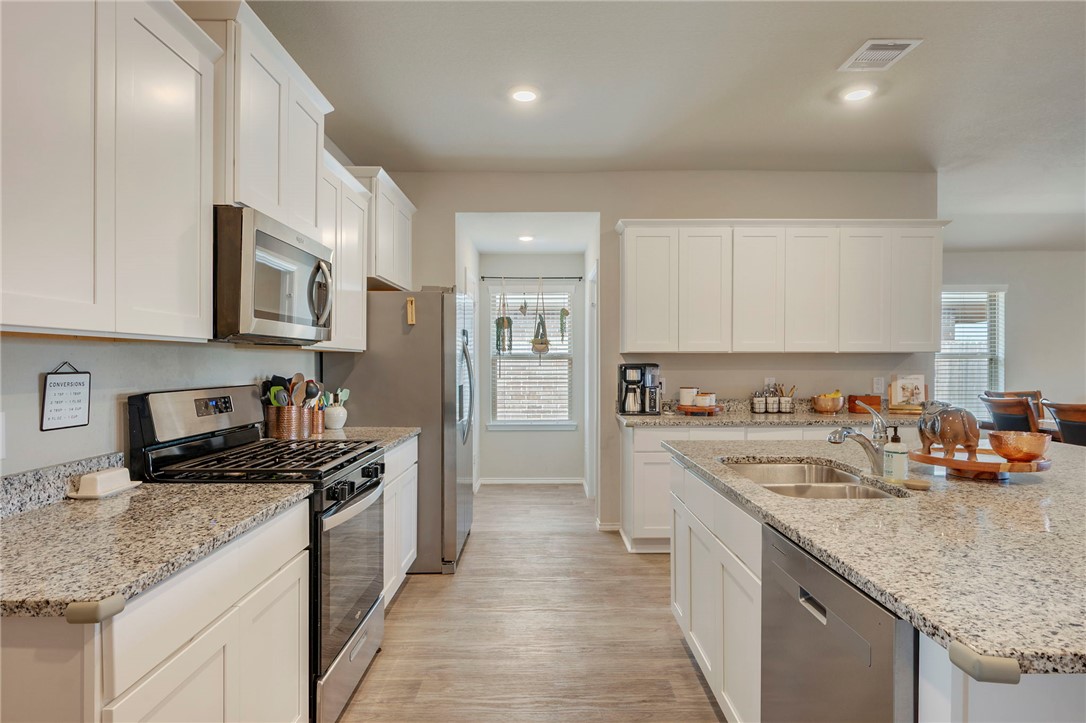 8026 Front Nine Lane Navasota, TX 77868 - Photo 5 of 22 a kitchen with stainless steel appliances granite countertop a sink stove and refrigerator