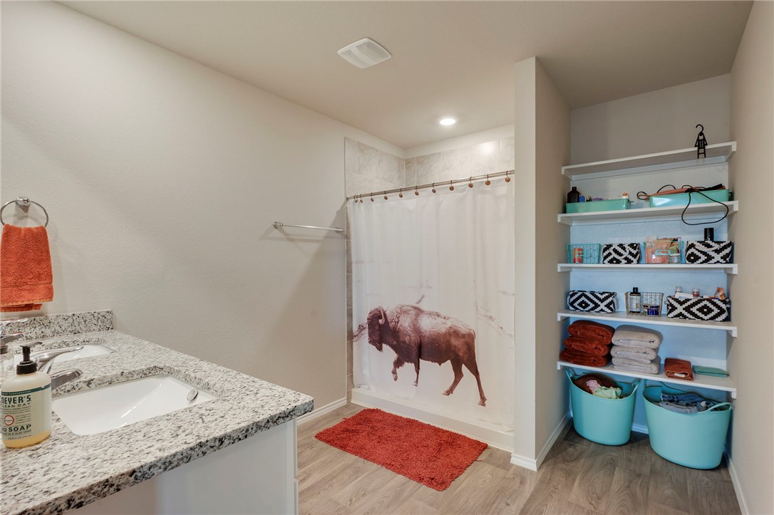 8026 Front Nine Lane Navasota, TX 77868 - Photo 10 of 22 a room with stainless steel appliances granite countertop a sink and a wooden floor