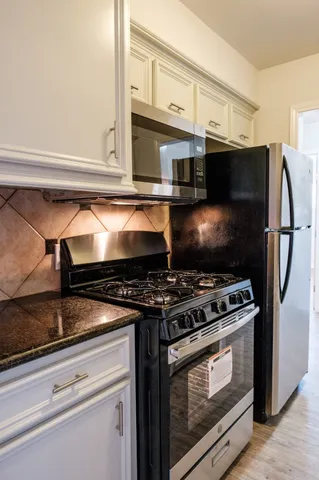 a stove top oven sitting inside of a kitchen