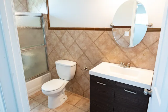 a bathroom with a toilet sink and mirror