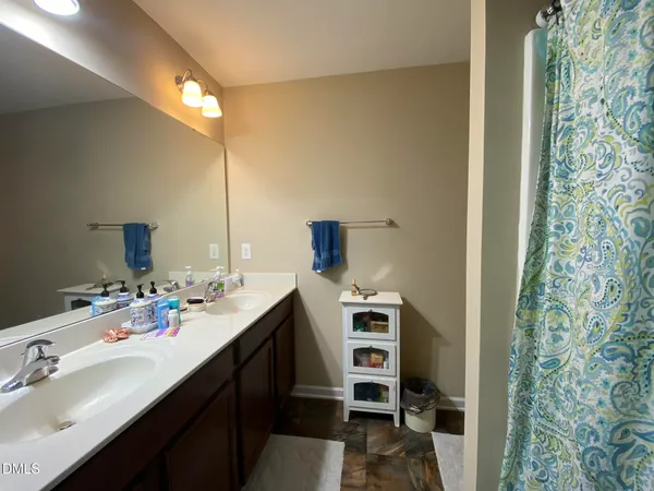 a bedroom with a bed a dresser and a flat screen tv