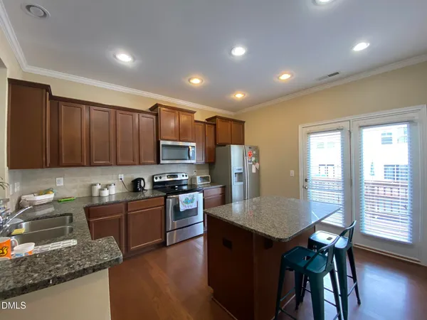 a kitchen with granite countertop sink table and chairs