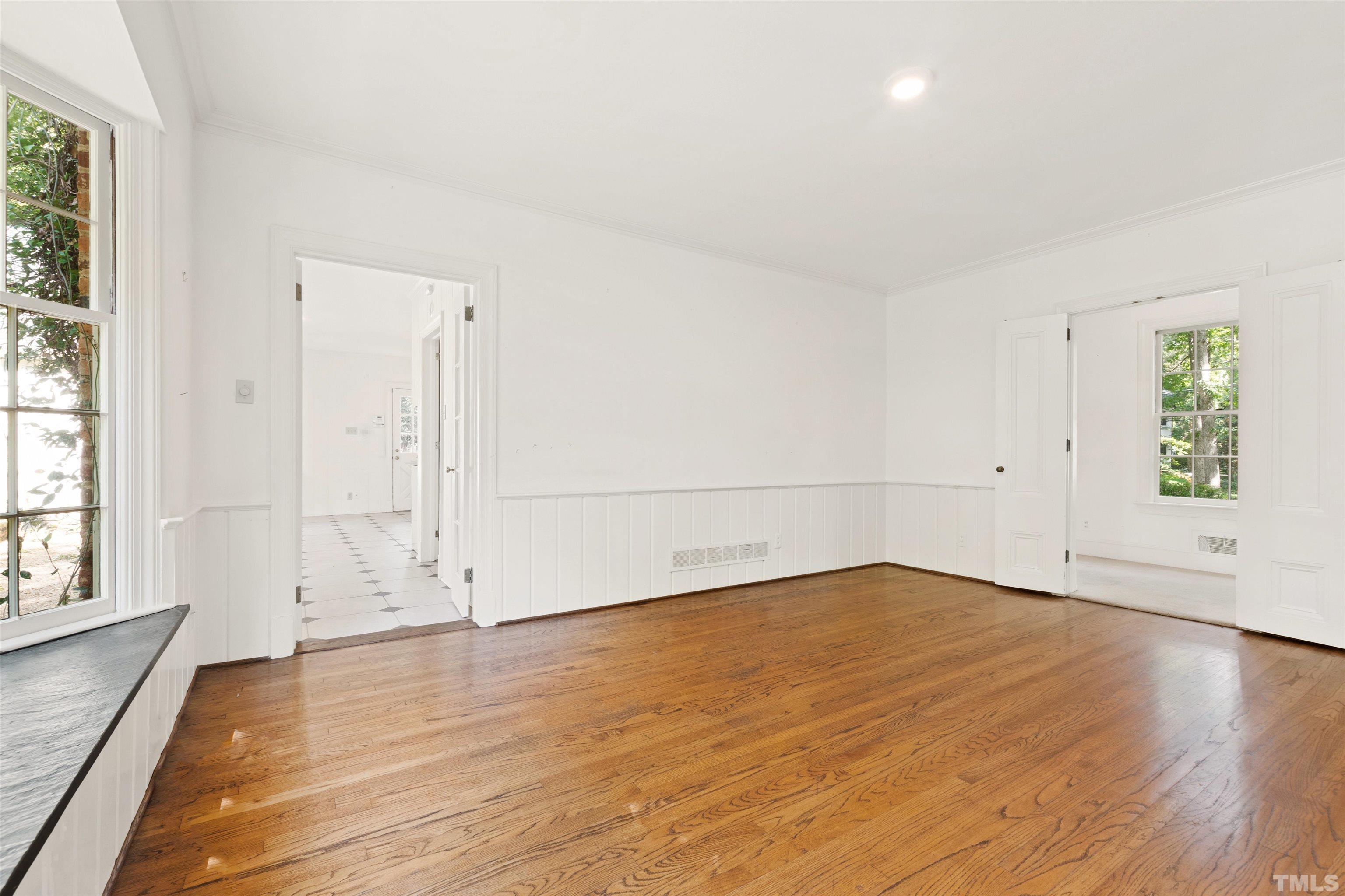 3231 Sussex Road Raleigh, NC 27607 - Photo 11 of 60 an empty room with wooden floor and windows