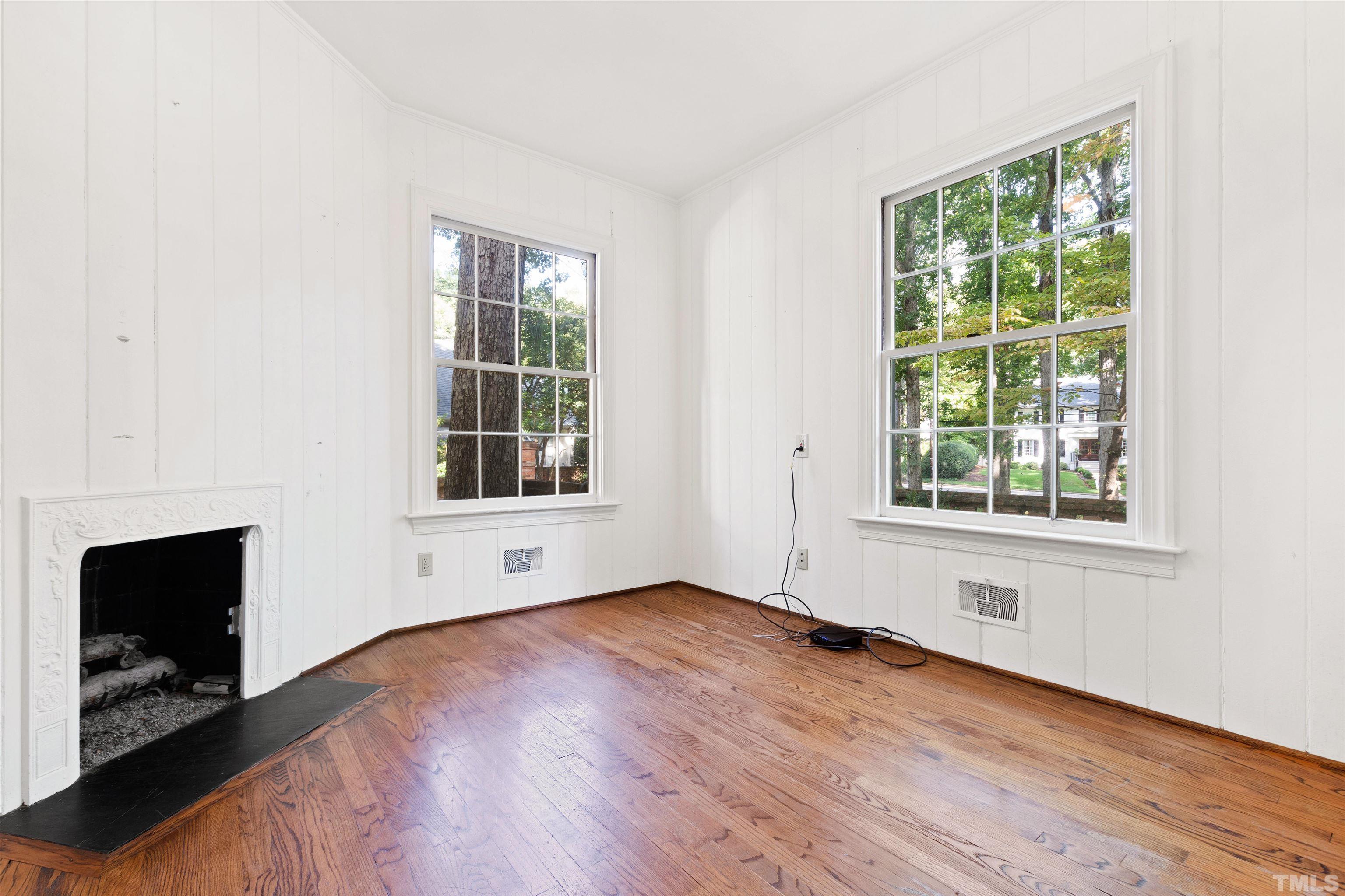 3231 Sussex Road Raleigh, NC 27607 - Photo 12 of 60 an empty room with wooden floor and windows