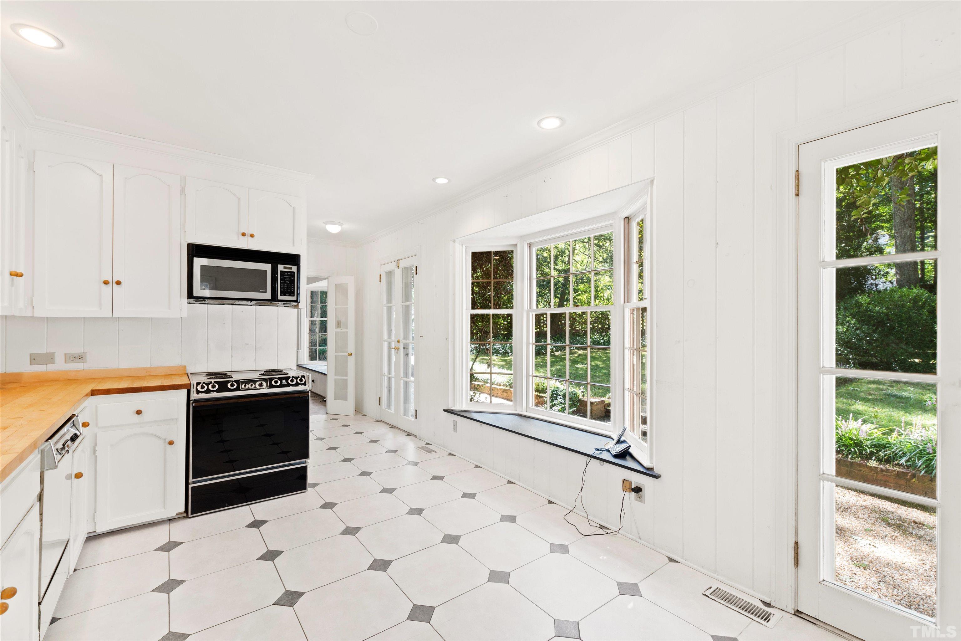 3231 Sussex Road Raleigh, NC 27607 - Photo 13 of 60 a kitchen with granite countertop a stove a sink and a refrigerator