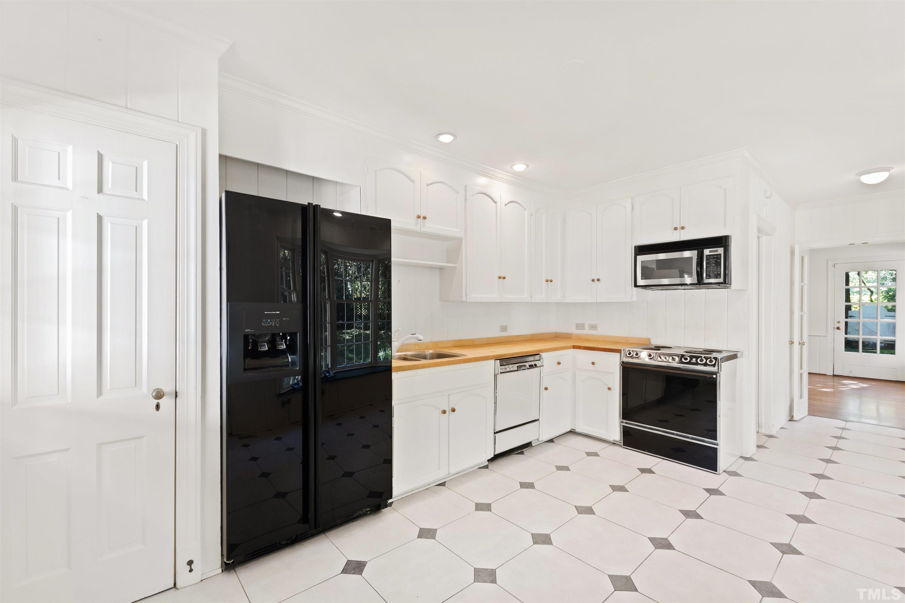 3231 Sussex Road Raleigh, NC 27607 - Photo 14 of 60 a large white kitchen with a sink and refrigerator