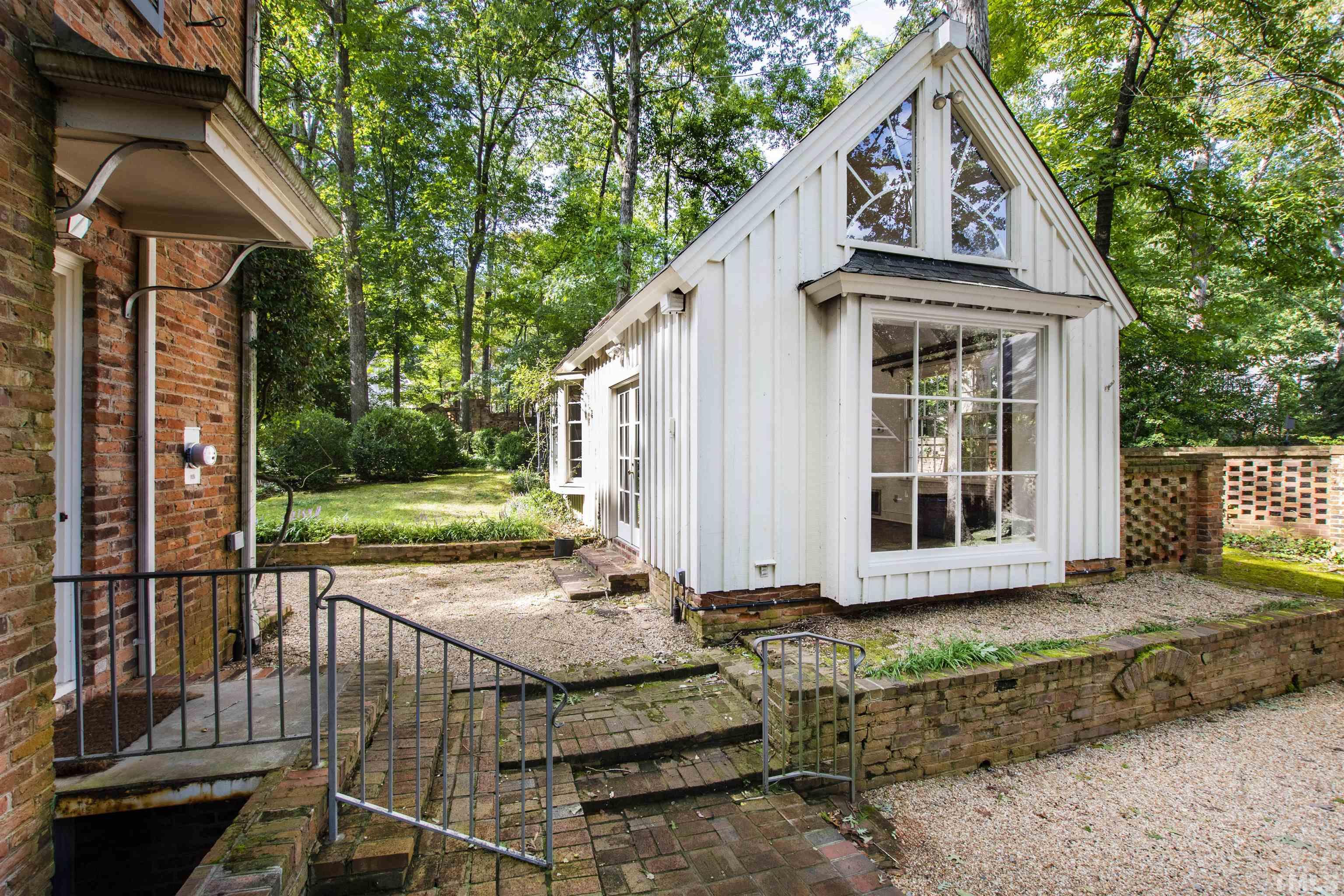 3231 Sussex Road Raleigh, NC 27607 - Photo 40 of 60 a view of a brick house with many windows next to a yard