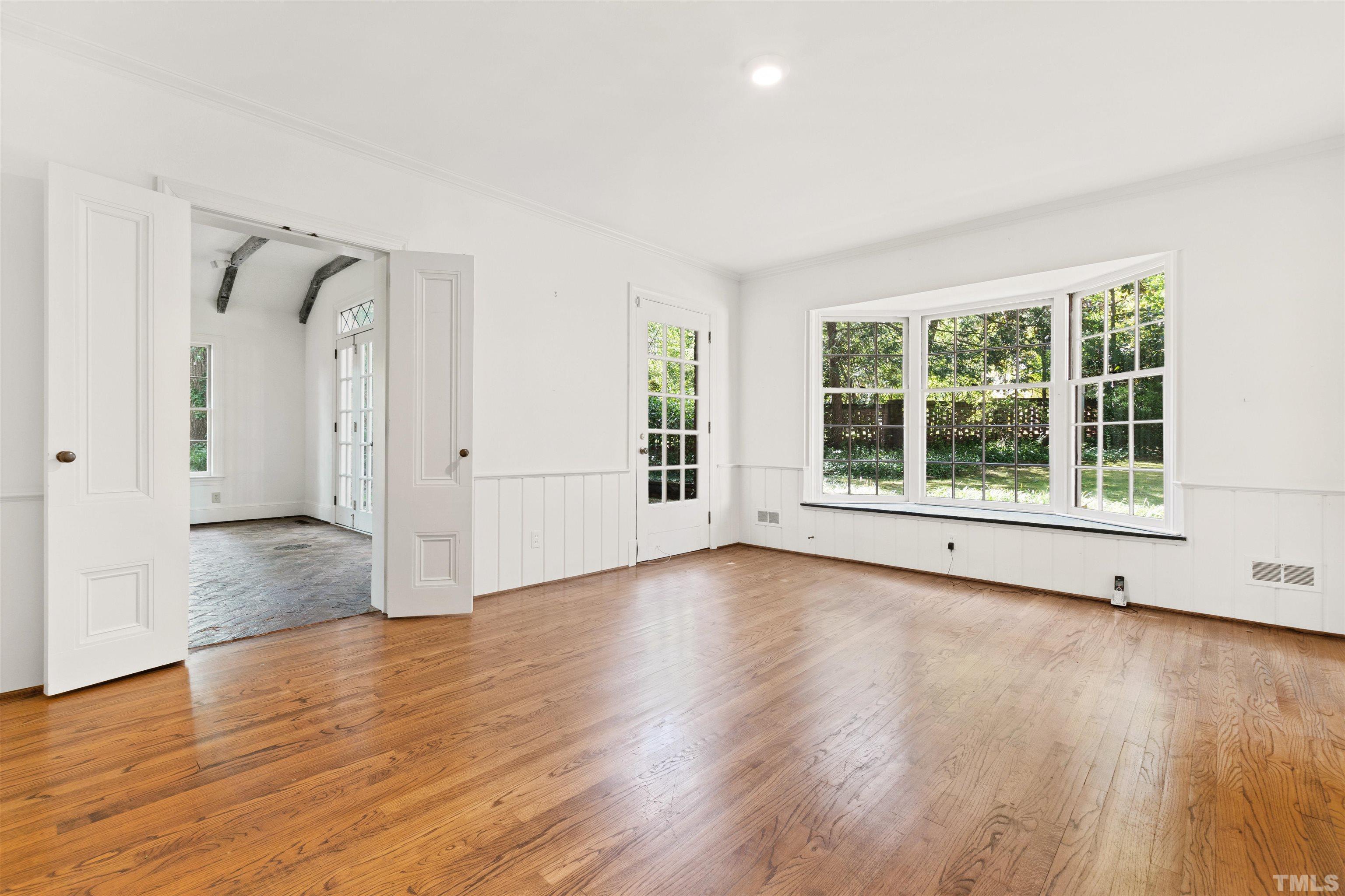 3231 Sussex Road Raleigh, NC 27607 - Photo 9 of 60 an empty room with wooden floor and windows