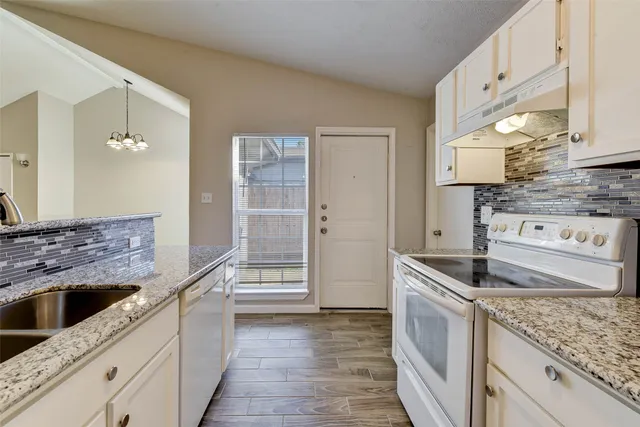 a kitchen with stainless steel appliances granite countertop a sink and a stove
