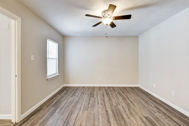 an empty room with a window and a fan