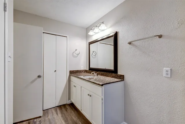 a view of bathroom with a sink mirror and wooden floor
