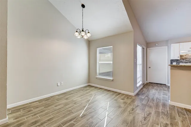 a view of empty room with wooden floor
