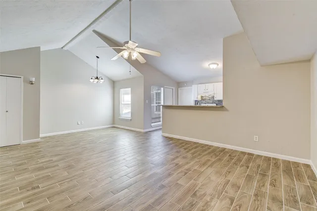 a view of a kitchen with wooden floor and a ceiling fan