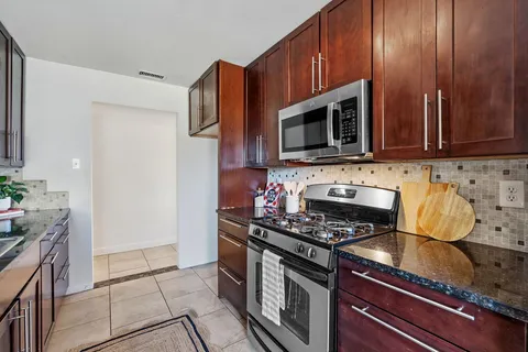 a kitchen with wooden cabinets and a stove top oven