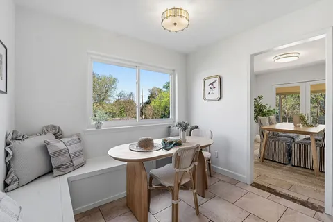 a dining room with furniture and a window