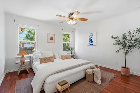 a bedroom with a bed table closet and a window