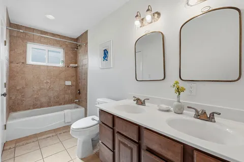 a bathroom with a double vanity sink mirror and toilet