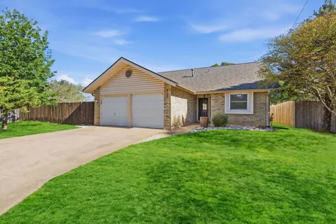 a front view of a house with yard and green space