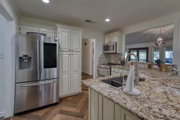 a kitchen with granite countertop a refrigerator and a sink