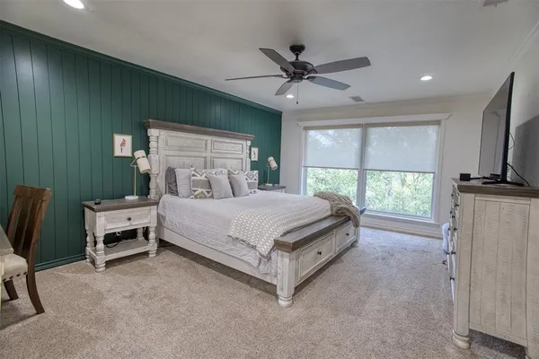 a bedroom with a bed a chandelier and a flat screen tv