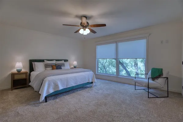 a spacious bedroom with a bed and a chair